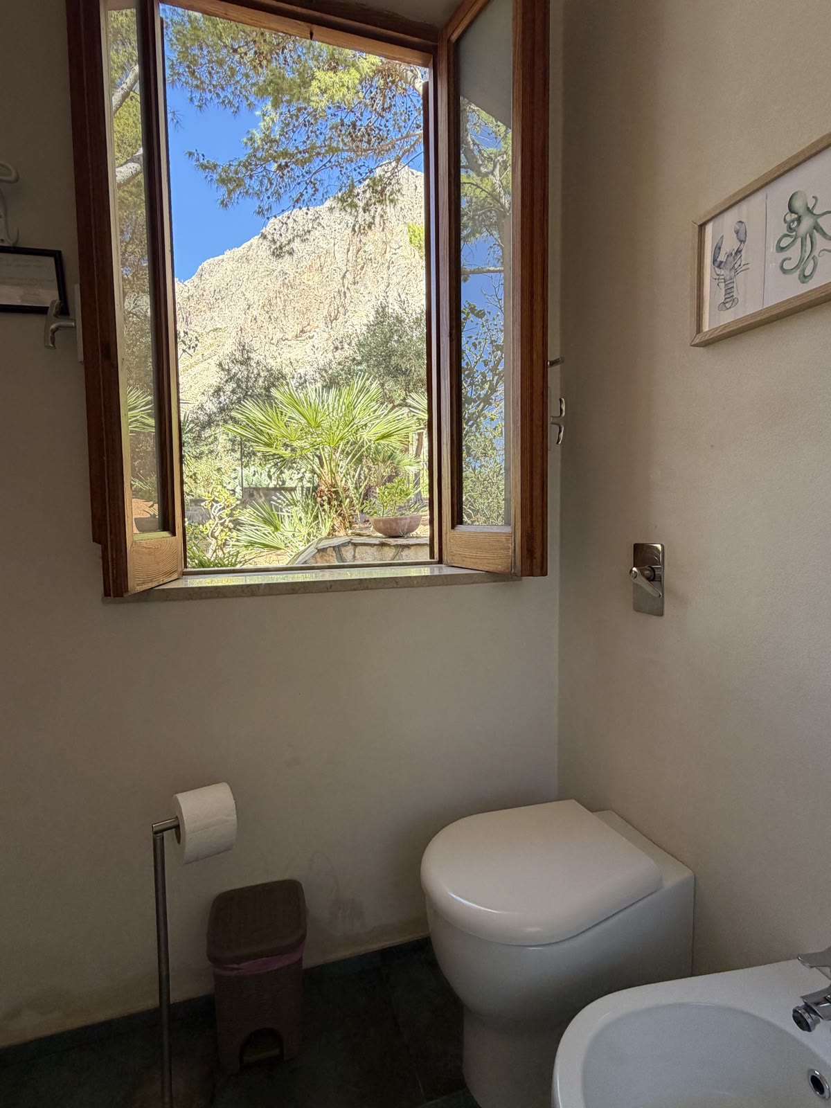 Bathroom with the window open onto the palm and the rock face of Monte Cofano