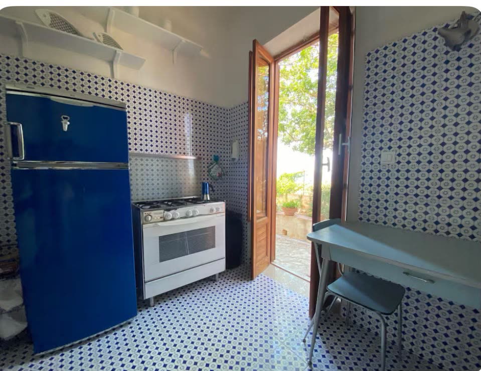 Kitchen with a blue fridge and a gas cooker