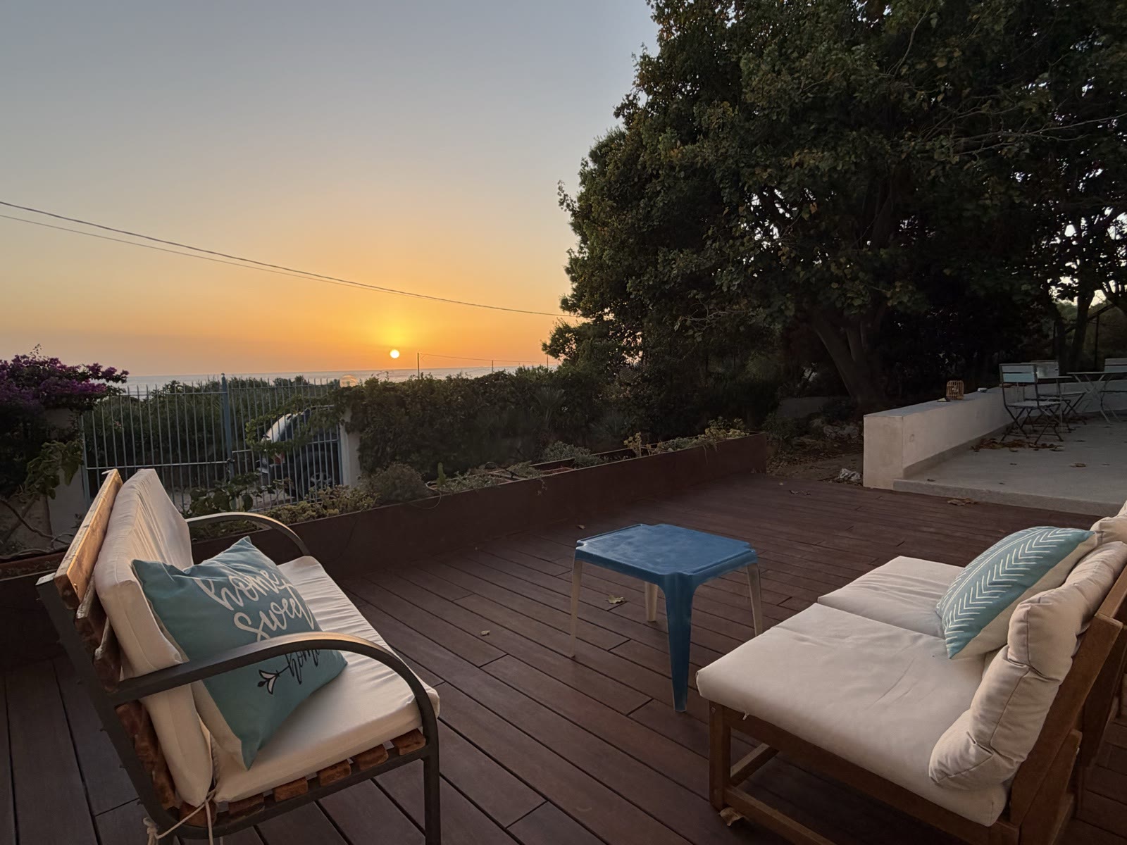 Wooden deck with sofas at sunset over the sea